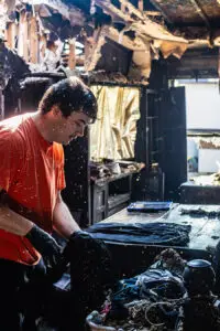 CRS employee in an orange shirt and black gloves